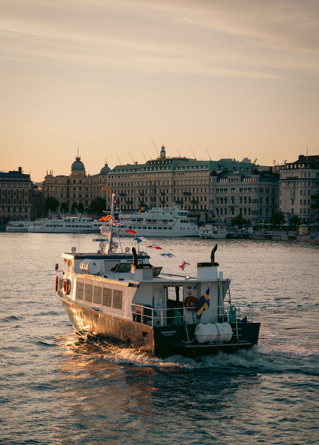 M/S Tranholmen på Strömmen i solnedgång framför Grand Hôtel